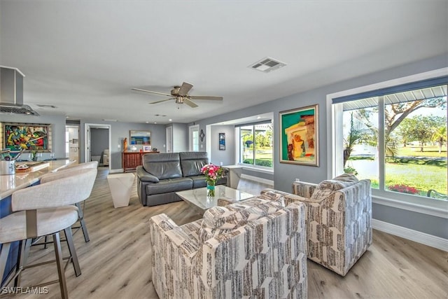 living room with ceiling fan and light wood-type flooring