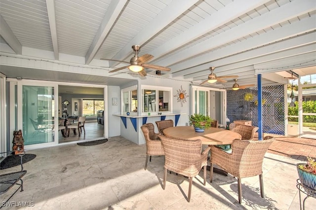 sunroom / solarium featuring ceiling fan and beam ceiling