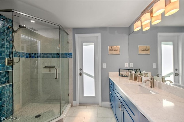 bathroom featuring vanity, a shower with shower door, and tile patterned floors