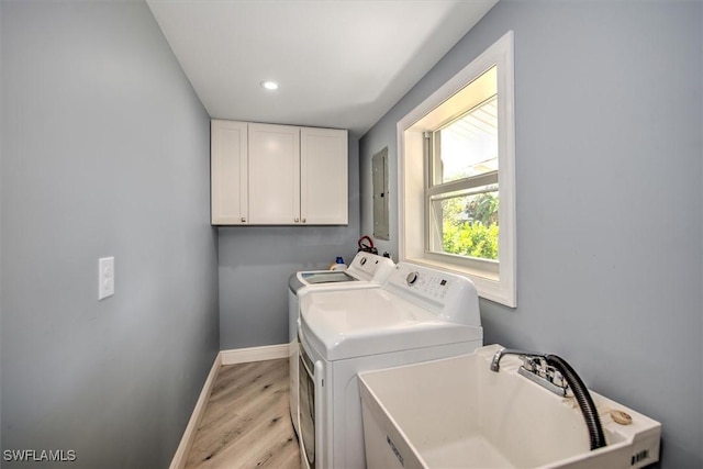 washroom with cabinets, sink, independent washer and dryer, and light hardwood / wood-style floors