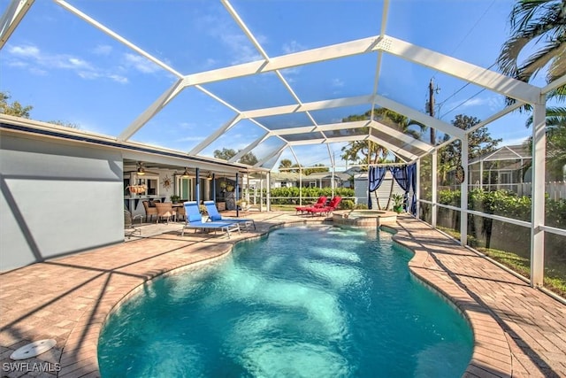 view of pool featuring a patio area, an in ground hot tub, and glass enclosure