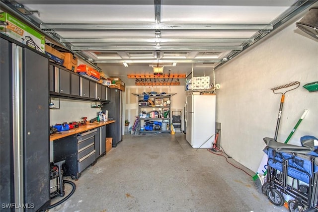 garage with a garage door opener and white fridge