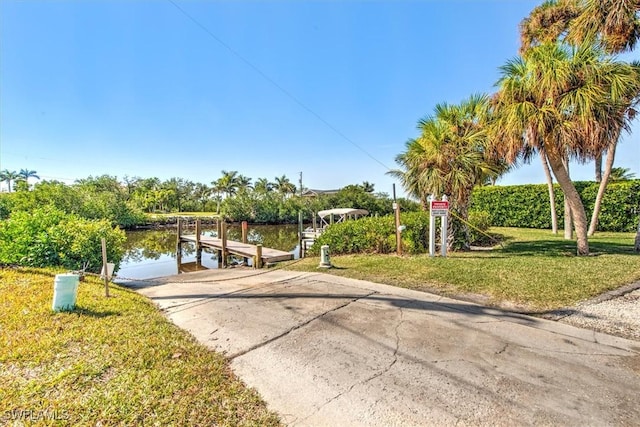 view of dock with a water view and a yard