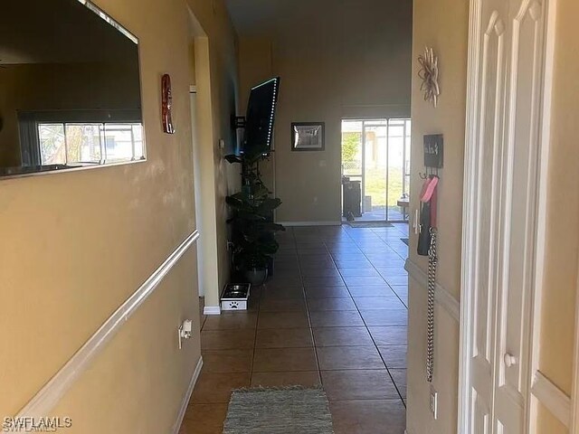 hall with dark tile patterned flooring