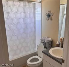 full bathroom with shower / bath combo, vanity, and toilet