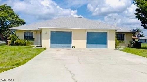 ranch-style home featuring an attached garage, stucco siding, concrete driveway, and a front yard