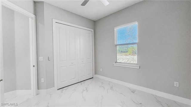 unfurnished bedroom with ceiling fan and a closet