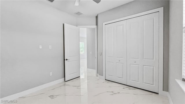 unfurnished bedroom featuring ceiling fan and a closet