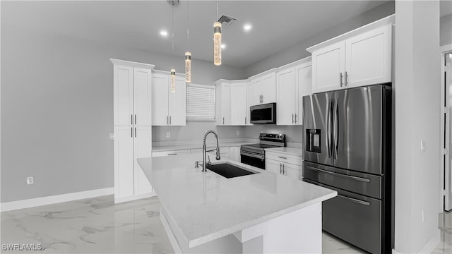 kitchen with sink, appliances with stainless steel finishes, white cabinetry, hanging light fixtures, and a center island with sink