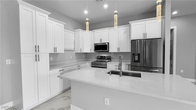 kitchen with stainless steel appliances, sink, pendant lighting, and white cabinets