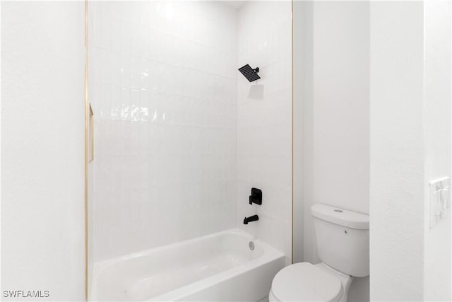 bathroom with tiled shower / bath combo and toilet