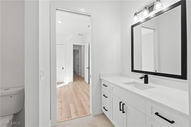 bathroom featuring vanity, tile patterned flooring, and toilet