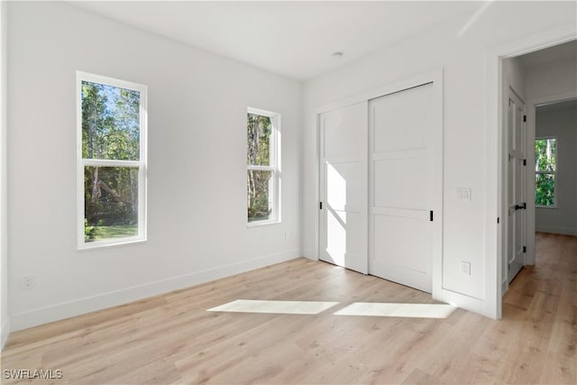 unfurnished bedroom featuring a closet and light wood-type flooring