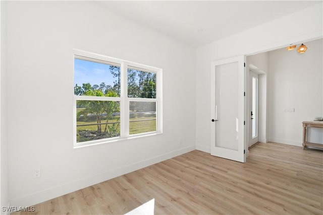 empty room featuring light wood finished floors and baseboards