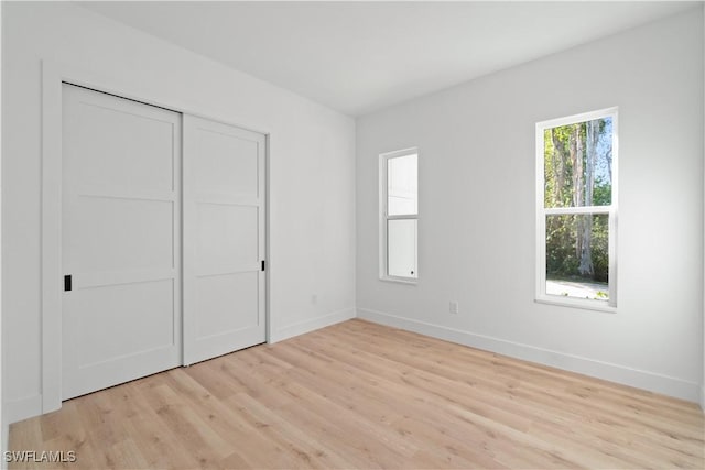 unfurnished bedroom with light hardwood / wood-style floors and a closet