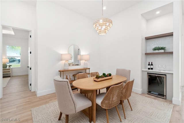 dining area with indoor bar, light hardwood / wood-style flooring, and a notable chandelier