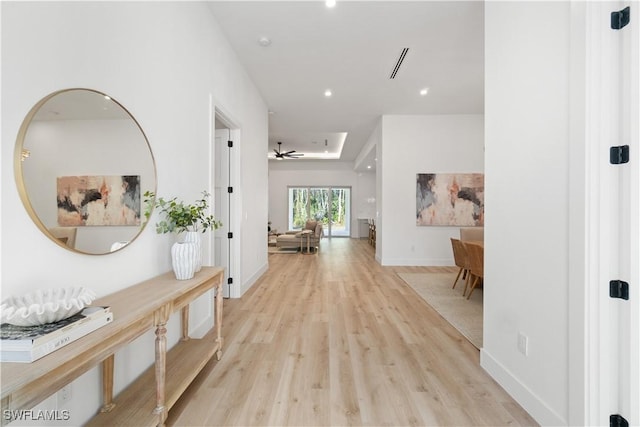 hallway featuring recessed lighting, visible vents, baseboards, and light wood-style floors