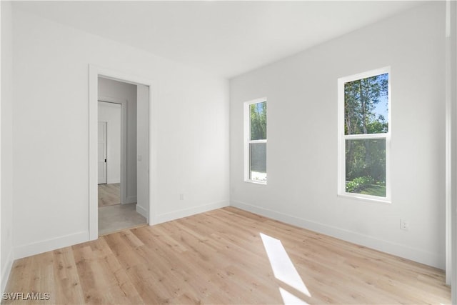 spare room with wood finished floors and baseboards