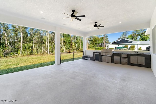 view of patio with a sink, ceiling fan, area for grilling, and exterior kitchen