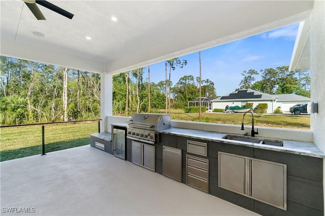 view of patio / terrace with sink, grilling area, ceiling fan, and an outdoor kitchen