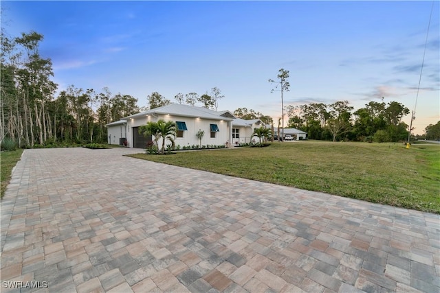 view of front facade featuring a garage and a lawn