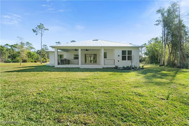 back of property with a yard, a patio, and ceiling fan