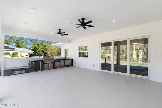 view of patio / terrace with ceiling fan, a grill, and exterior kitchen