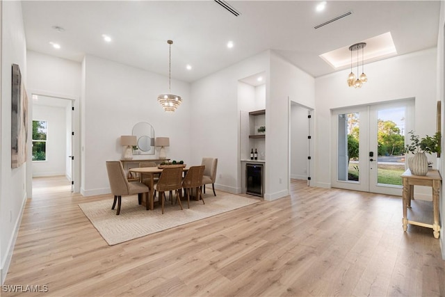 dining room with visible vents, baseboards, a notable chandelier, and light wood-style floors