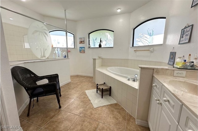 bathroom with vanity, tile patterned floors, and tiled bath