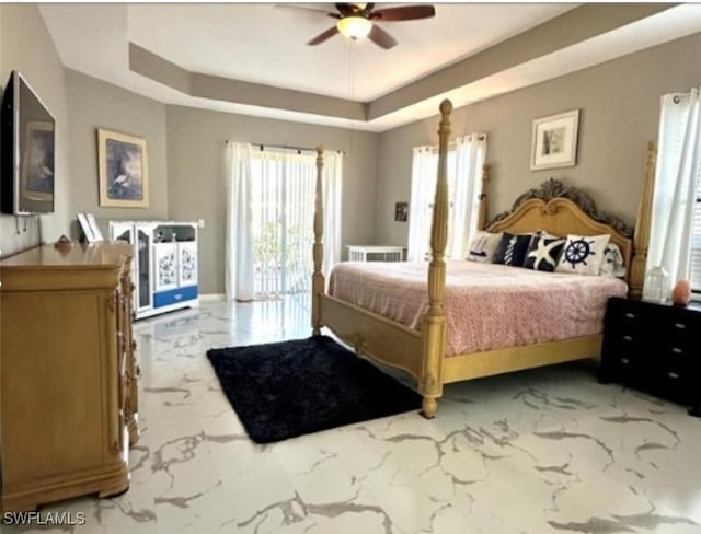 bedroom with ceiling fan and a tray ceiling