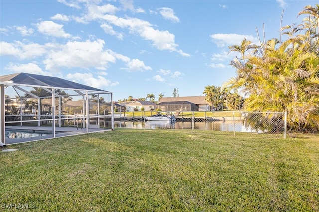 view of yard with a water view and glass enclosure