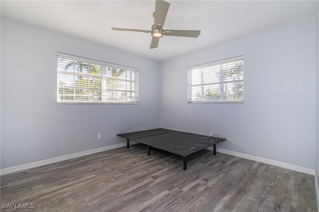 unfurnished room with ceiling fan and dark hardwood / wood-style flooring