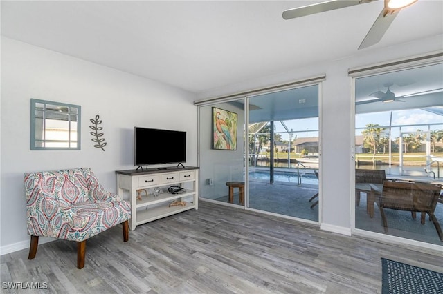 living area with hardwood / wood-style floors and ceiling fan