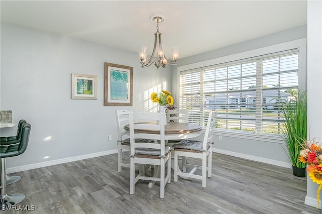 dining space featuring wood-type flooring and a chandelier