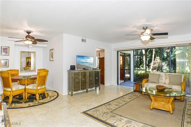 living area with ceiling fan, visible vents, and baseboards