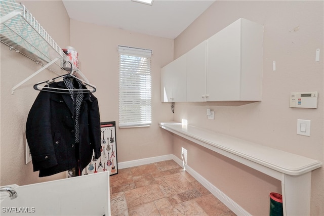 clothes washing area featuring cabinets