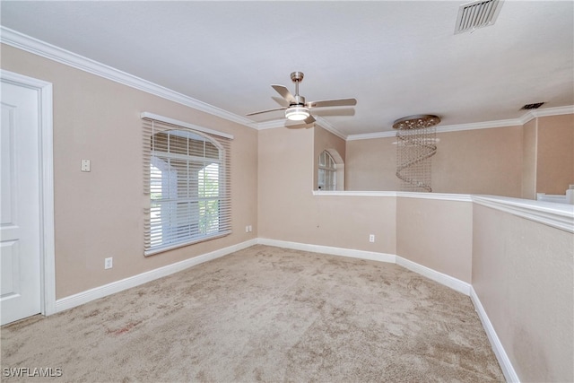 spare room with ceiling fan, ornamental molding, and light carpet