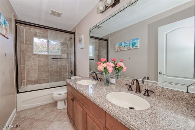 full bathroom with toilet, tile patterned floors, bath / shower combo with glass door, and vanity