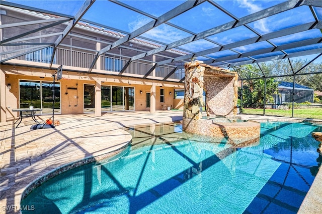 view of pool with a jacuzzi, a patio, and a lanai