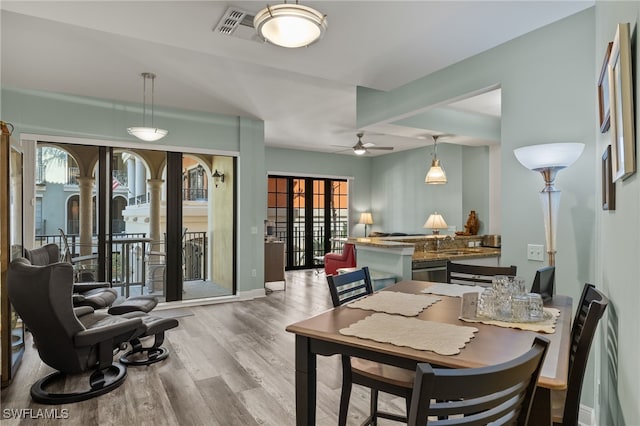 dining area with a ceiling fan, visible vents, plenty of natural light, and wood finished floors