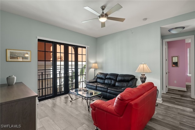 living area featuring french doors, a ceiling fan, baseboards, and wood finished floors