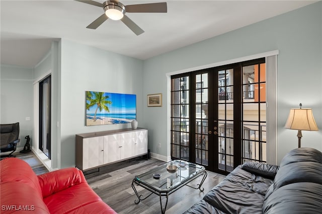 living area with french doors, wood finished floors, a ceiling fan, and baseboards