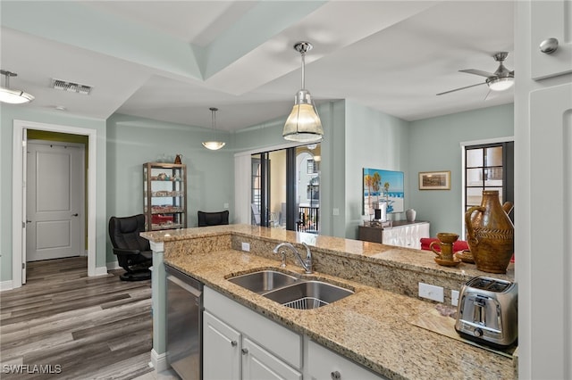 kitchen featuring wood finished floors, a sink, visible vents, hanging light fixtures, and dishwasher