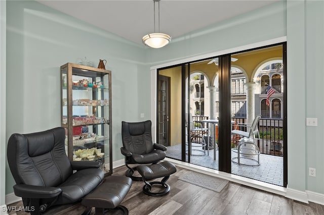 sitting room with baseboards and wood finished floors