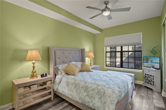 bedroom with ceiling fan, wood finished floors, and baseboards