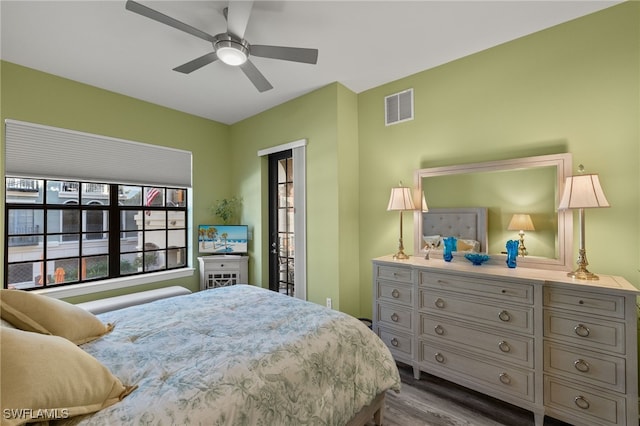 bedroom featuring dark wood-style floors, visible vents, and a ceiling fan