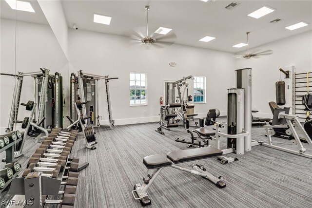 gym featuring a high ceiling, ceiling fan, and carpet