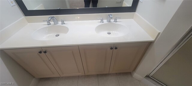 bathroom with tile patterned flooring, vanity, and a shower with door