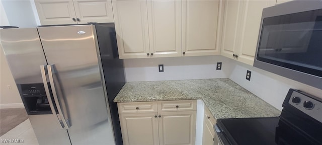 kitchen featuring light stone counters and stainless steel appliances