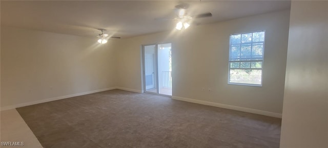 unfurnished room with ceiling fan and dark carpet